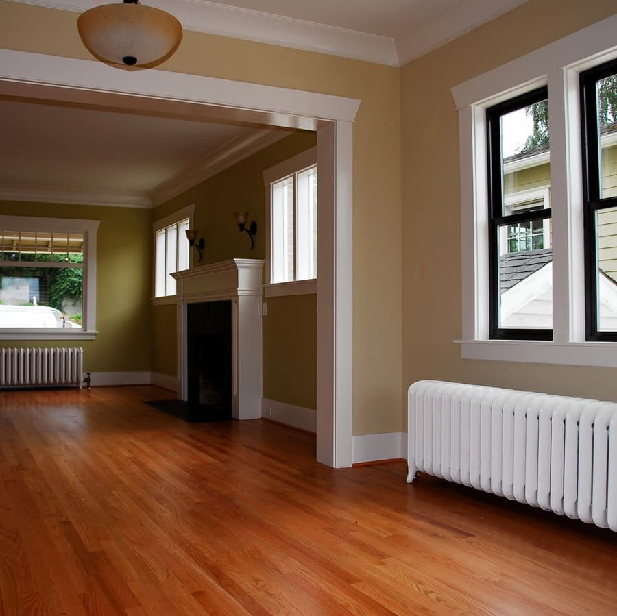 A craftsman-style room with a restored cast-iron radiator, hardwood floors and white trim.